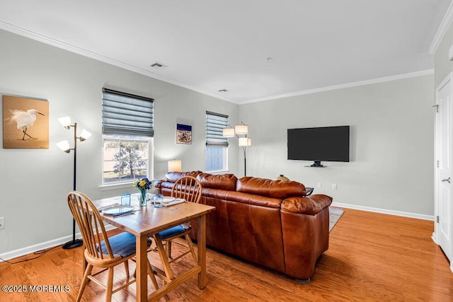 living area featuring crown molding, wood finished floors, visible vents, and baseboards