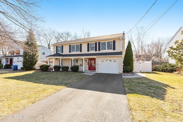 view of front of home featuring fence, a front lawn, driveway, and a gate