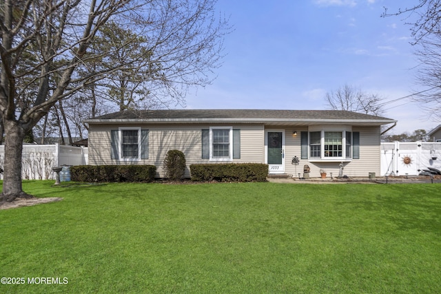 ranch-style home featuring a gate, a front yard, and fence