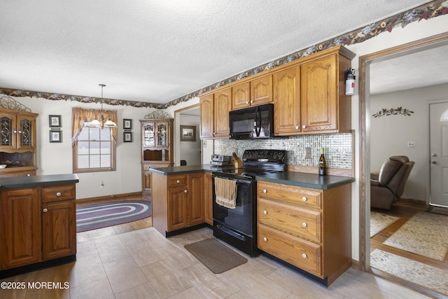 kitchen with backsplash, dark countertops, black appliances, and brown cabinetry