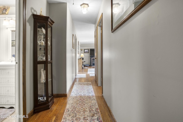 hallway with baseboards and wood finished floors