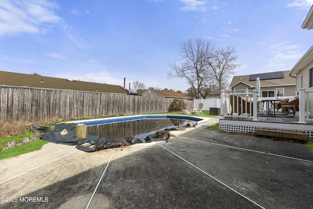 view of swimming pool with a fenced in pool, a patio, a wooden deck, and a fenced backyard