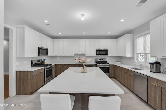 71 Broadway Ave, Lakewood, NJ 08701 - kitchen with stainless steel appliances, visible vents, a sink, white cabinetry, and light countertops