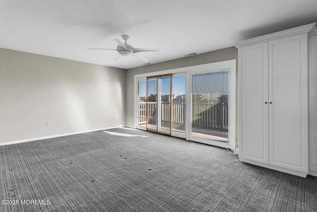 carpeted spare room featuring visible vents, baseboards, and ceiling fan