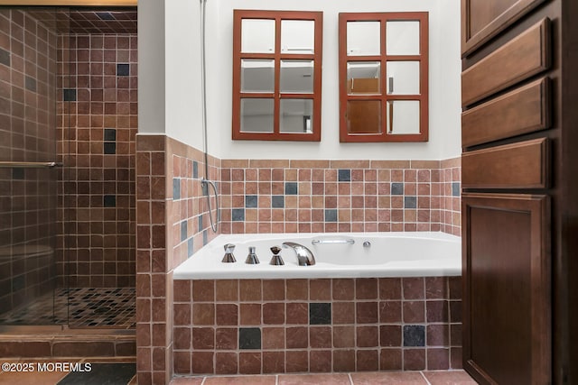 bathroom with a garden tub and a tile shower