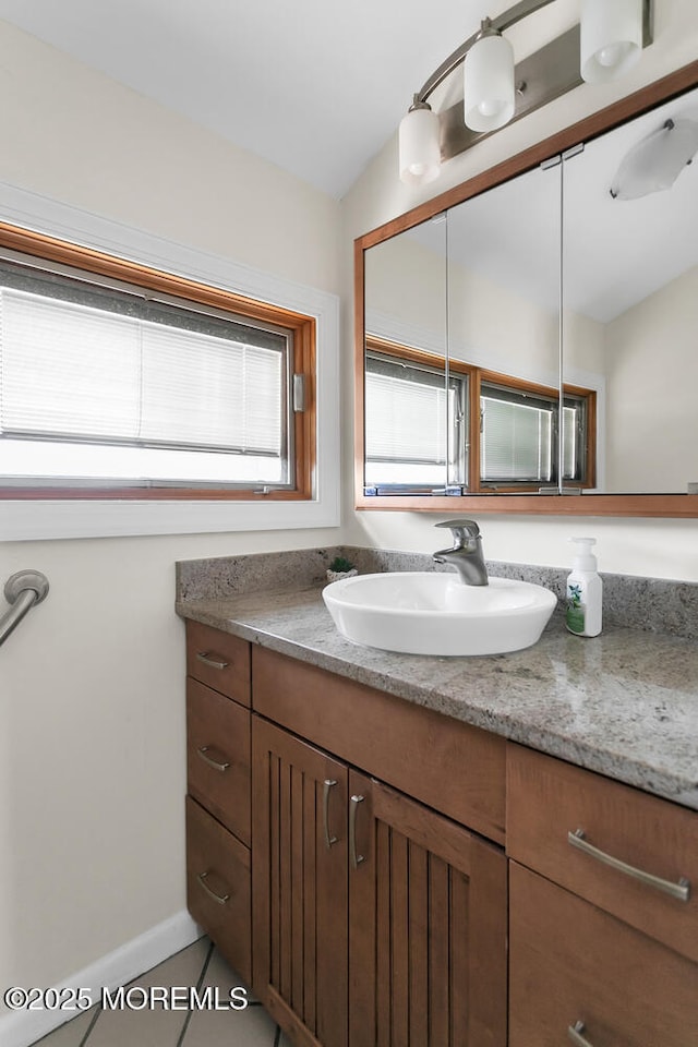 bathroom featuring vanity, vaulted ceiling, and baseboards