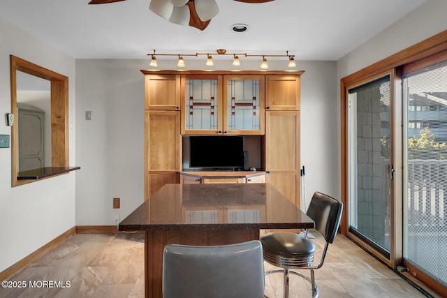 office space featuring baseboards, ceiling fan, and track lighting