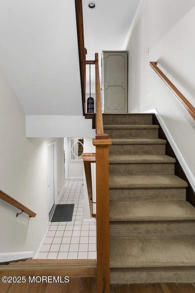 stairway with tile patterned floors and baseboards