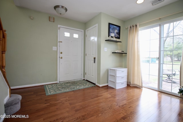 entryway featuring visible vents, baseboards, and wood finished floors