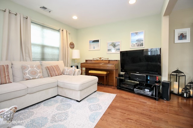 living area featuring recessed lighting, visible vents, and wood finished floors