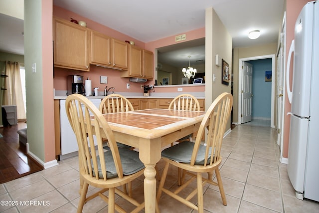 dining room featuring light tile patterned floors, baseboards, and an inviting chandelier