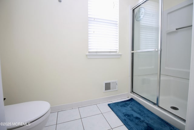 bathroom featuring visible vents, baseboards, toilet, a stall shower, and tile patterned floors