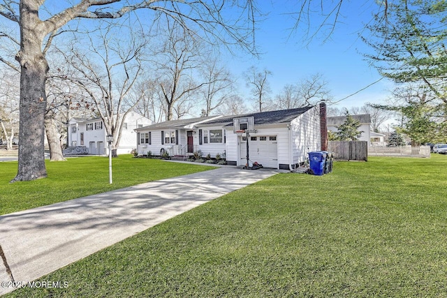 view of front of property with a front lawn, fence, concrete driveway, an attached garage, and a chimney