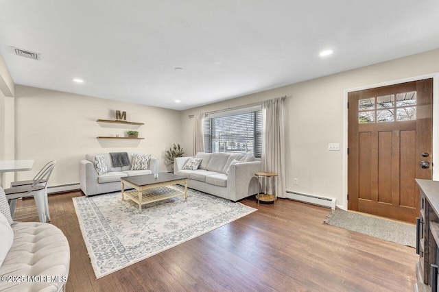 living area featuring visible vents, recessed lighting, a baseboard heating unit, and wood finished floors