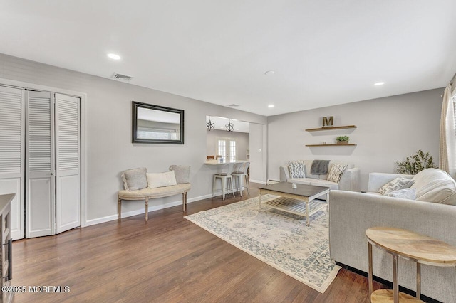 living room with dark wood finished floors, visible vents, recessed lighting, and baseboards