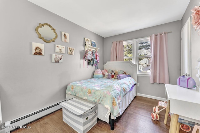 bedroom featuring wood finished floors, baseboards, and a baseboard radiator