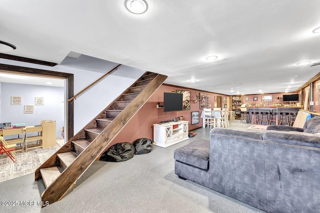 living area with stairway and a dry bar