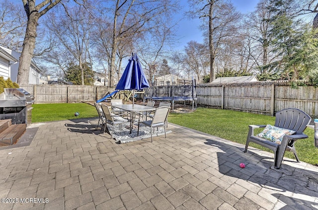 view of patio with a trampoline and a fenced backyard