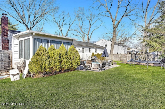 view of yard featuring a patio area, a trampoline, and fence