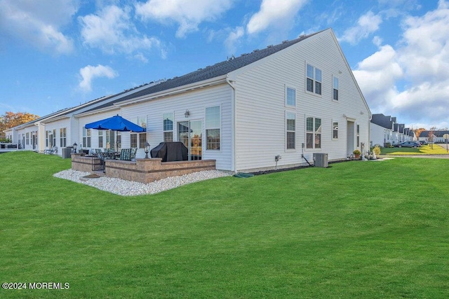 back of property featuring a yard, cooling unit, and a patio area