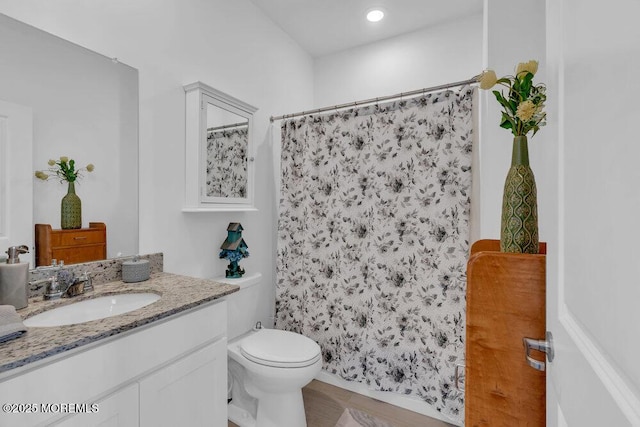bathroom with toilet, curtained shower, and vanity