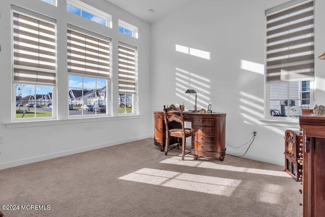 home office with a wealth of natural light, baseboards, and carpet