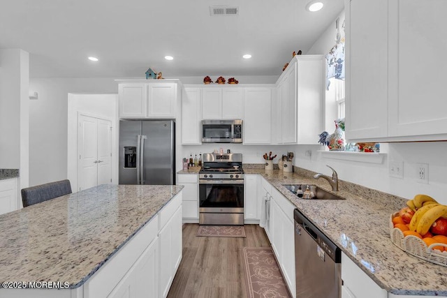 kitchen featuring light wood-type flooring, visible vents, a sink, recessed lighting, and stainless steel appliances