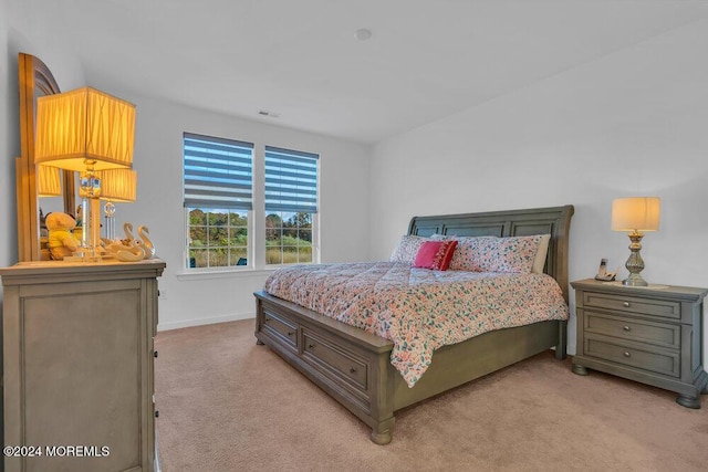 bedroom with visible vents, baseboards, and light carpet