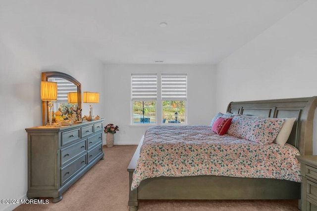 bedroom featuring baseboards and light carpet