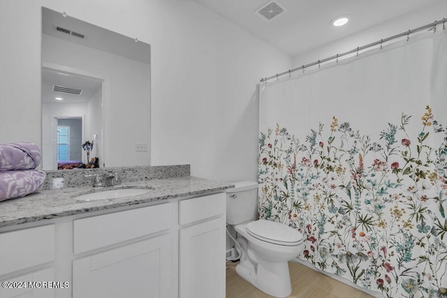 full bath featuring visible vents, toilet, and vanity