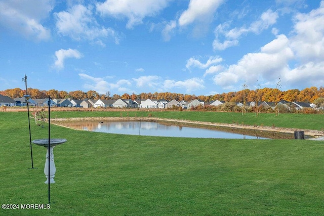 view of home's community featuring a residential view, a yard, and a water view