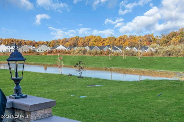 view of home's community with a yard, a water view, and a residential view