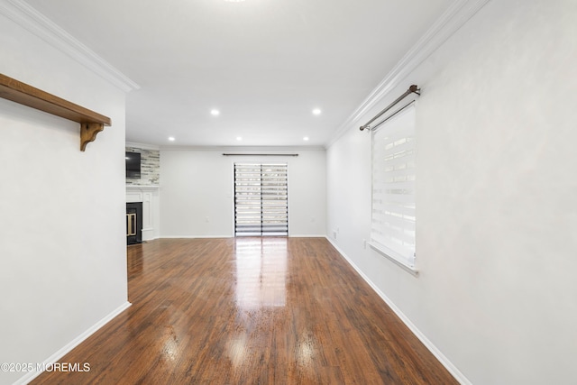 unfurnished living room featuring crown molding, baseboards, and wood finished floors