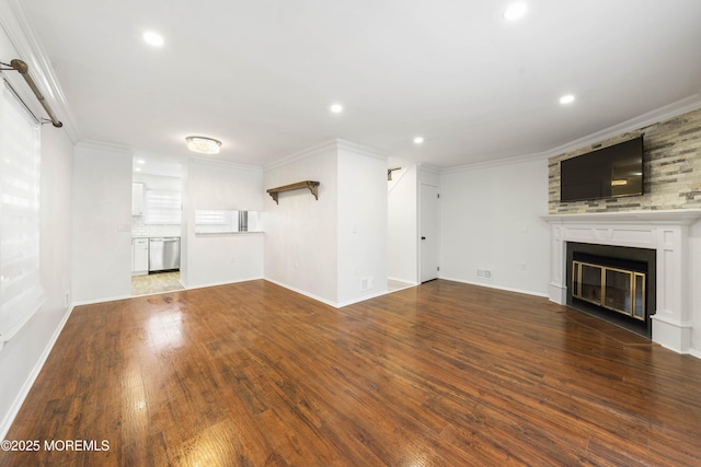 unfurnished living room featuring recessed lighting, a glass covered fireplace, ornamental molding, and wood-type flooring