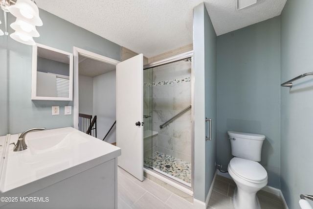 full bath featuring baseboards, toilet, a stall shower, a textured ceiling, and vanity