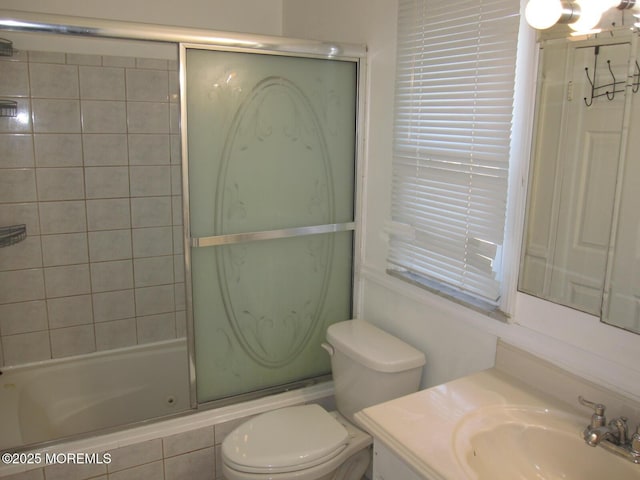 full bathroom featuring vanity, toilet, and bath / shower combo with glass door