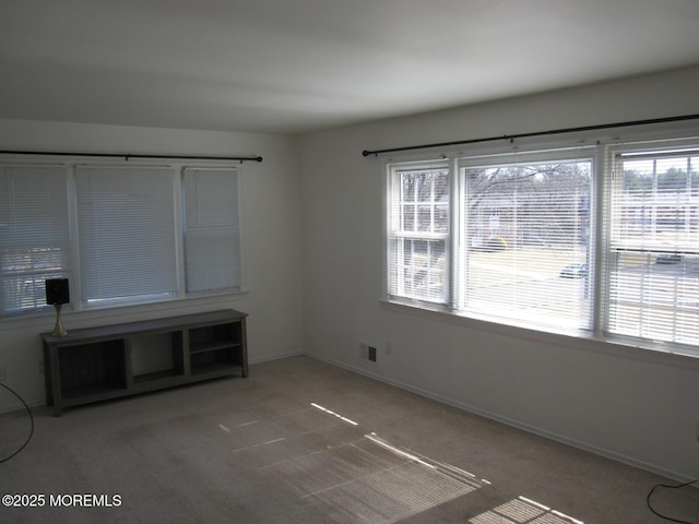 unfurnished room with baseboards and carpet