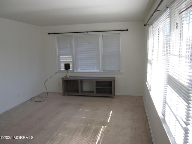 empty room featuring baseboards and carpet floors