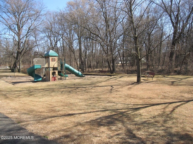 community jungle gym with fence and a lawn