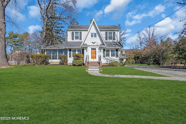 shingle-style home with a chimney, a front lawn, and roof with shingles