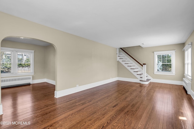 interior space with stairway, radiator, baseboards, and wood finished floors