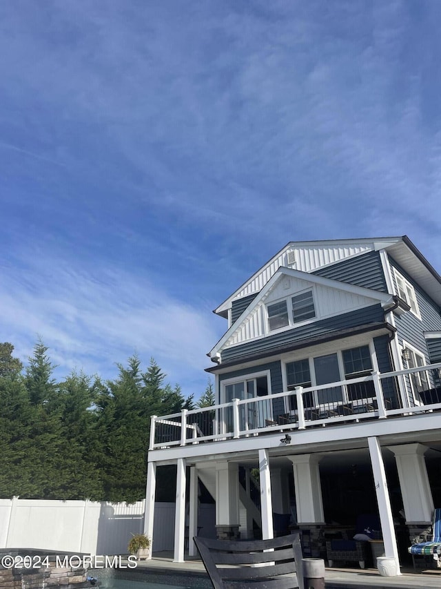 back of house featuring stairway and fence