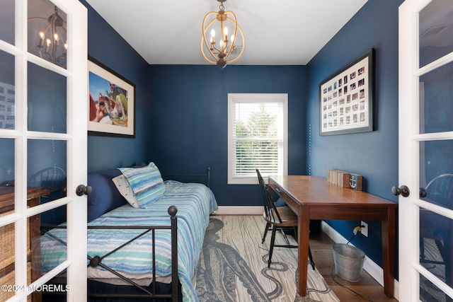 bedroom with a notable chandelier, french doors, baseboards, and wood finished floors