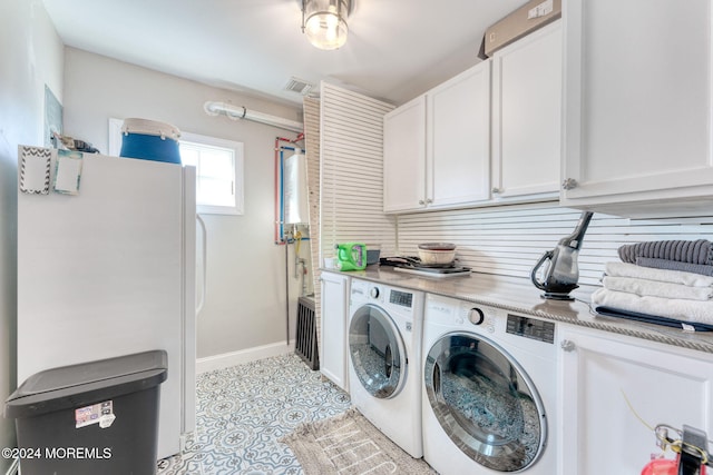 laundry room with visible vents, baseboards, washer and clothes dryer, light tile patterned floors, and cabinet space