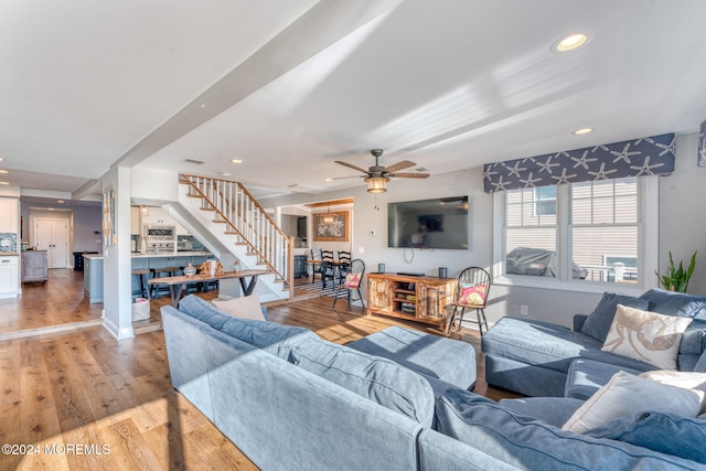 living room featuring recessed lighting, light wood-style floors, baseboards, ceiling fan, and stairs