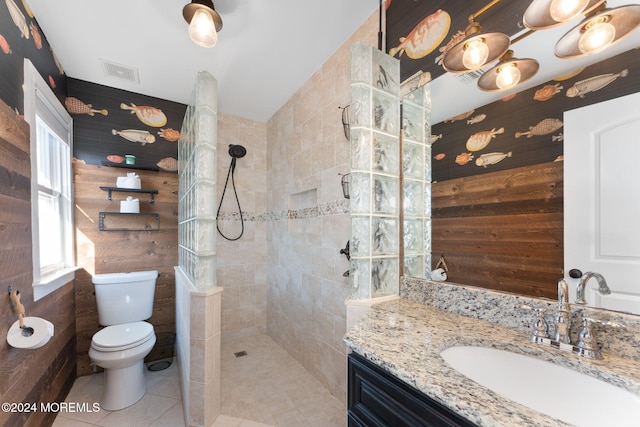 bathroom featuring vanity, visible vents, a walk in shower, tile patterned floors, and toilet