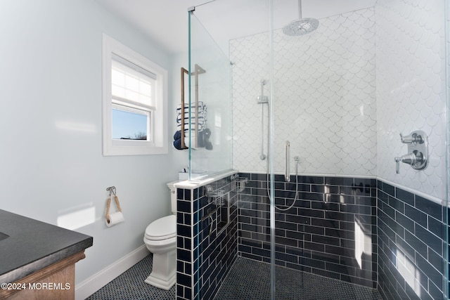 bathroom featuring a tile shower, toilet, and vanity