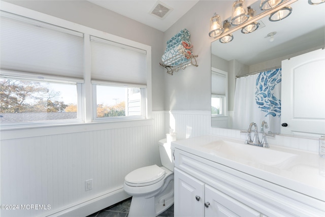 full bath featuring visible vents, toilet, wainscoting, vanity, and a baseboard radiator