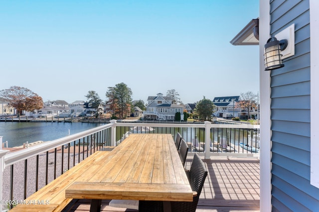 wooden deck with a residential view and a water view