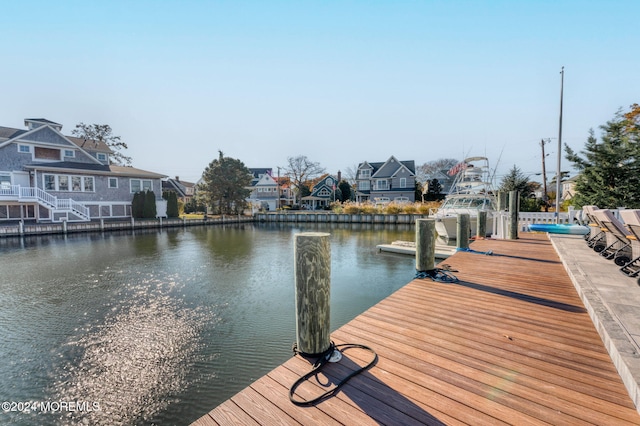 view of dock featuring a residential view and a water view